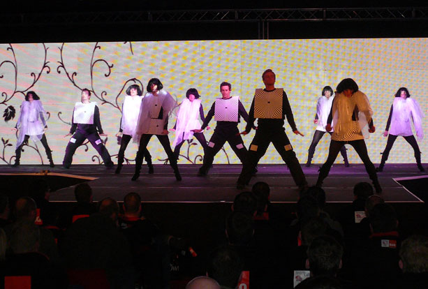 Stage performers with large AV backdrop